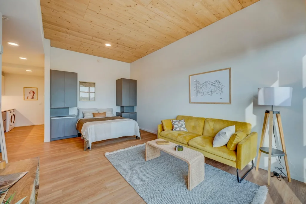 Studio with bed and sofa under timber